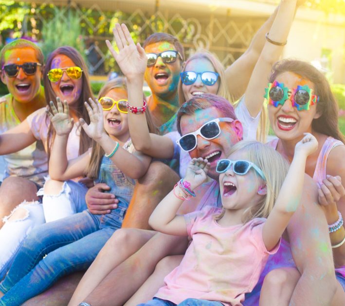 Friends enjoying a colourful outdoor festival together